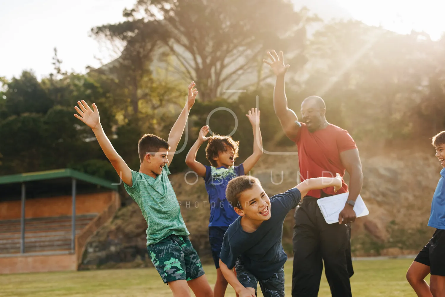 Elementary school kids celebrating with their sports coach